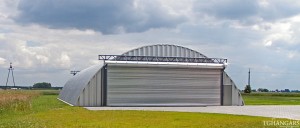 Lekkie samonośne hangary łukowe (arch prefabricated building) z alucynku - hangar lotniczy postojowy TG Hangars na prywatnym lądowisku.
